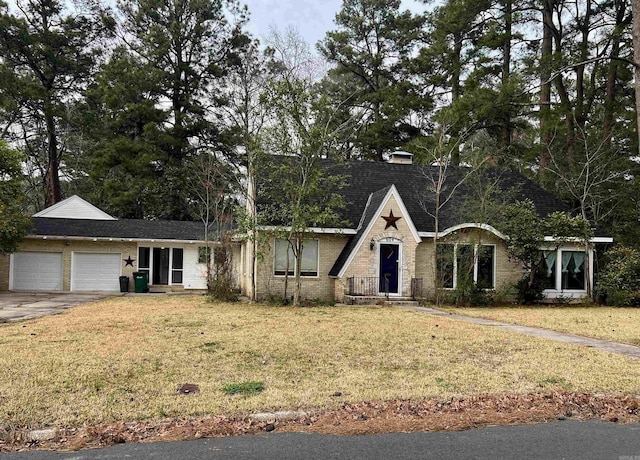 view of front of property with brick siding, an attached garage, driveway, and a front yard