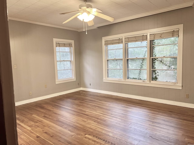 unfurnished room featuring baseboards, crown molding, a ceiling fan, and wood finished floors