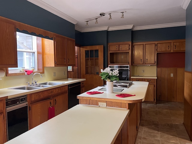 kitchen featuring black appliances, ornamental molding, brown cabinets, and a sink