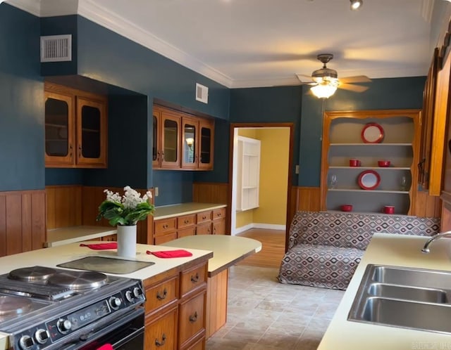 kitchen featuring visible vents, black stove, light countertops, and a sink