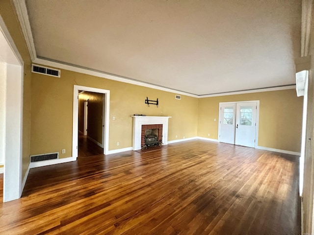 unfurnished living room with visible vents, baseboards, wood finished floors, and crown molding