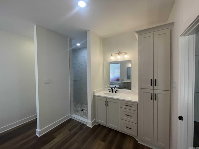 full bathroom with a walk in shower, wood finished floors, recessed lighting, baseboards, and vanity