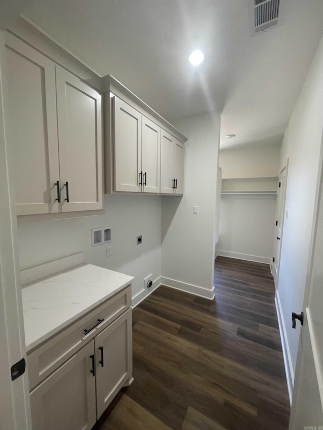 laundry room with electric dryer hookup, visible vents, washer hookup, dark wood finished floors, and cabinet space