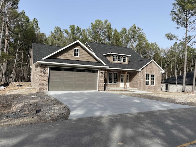 view of front of property featuring an attached garage, brick siding, driveway, and roof with shingles