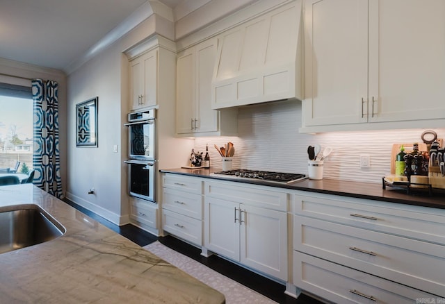 kitchen with dark stone countertops, appliances with stainless steel finishes, crown molding, decorative backsplash, and custom exhaust hood