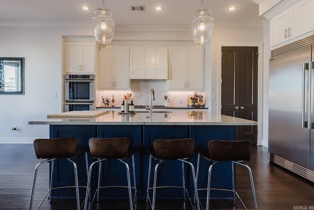 kitchen featuring visible vents, ornamental molding, a sink, tasteful backsplash, and stainless steel appliances