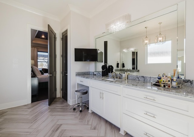 ensuite bathroom featuring baseboards, ensuite bath, ornamental molding, and vanity