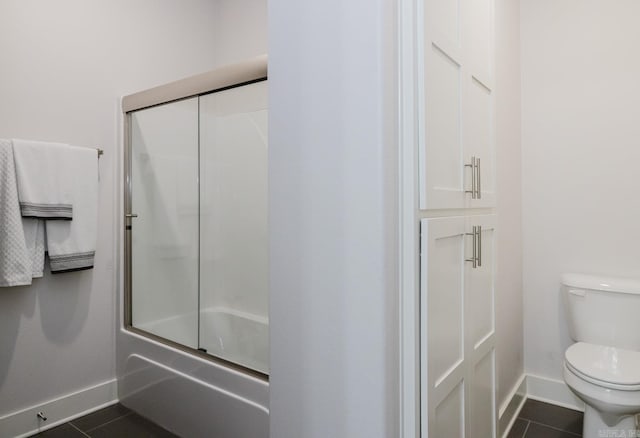 full bathroom featuring enclosed tub / shower combo, baseboards, toilet, and tile patterned flooring