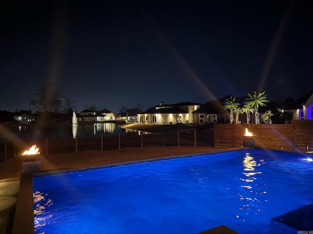 pool at twilight featuring a fenced in pool and a fenced backyard