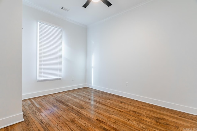 empty room featuring visible vents, crown molding, baseboards, ceiling fan, and wood finished floors