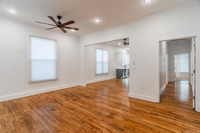 unfurnished living room featuring crown molding, wood finished floors, and ceiling fan