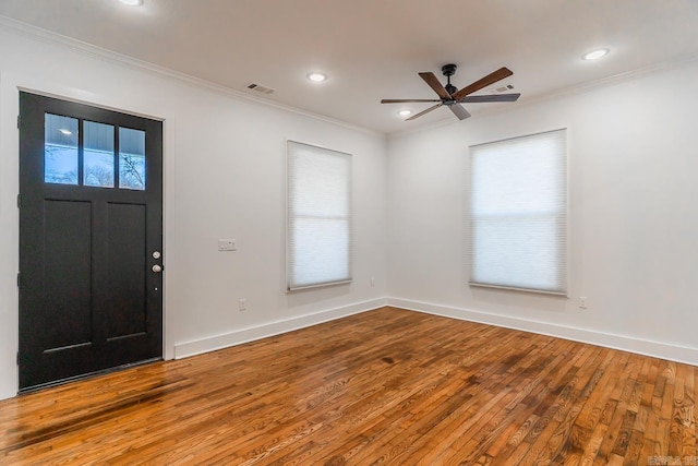 entrance foyer featuring visible vents, hardwood / wood-style floors, baseboards, and ornamental molding