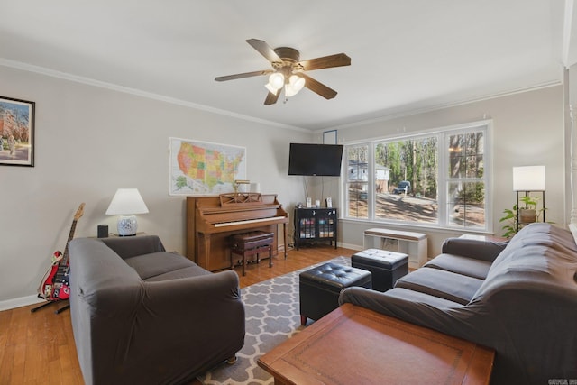 living area featuring ceiling fan, baseboards, wood finished floors, and ornamental molding