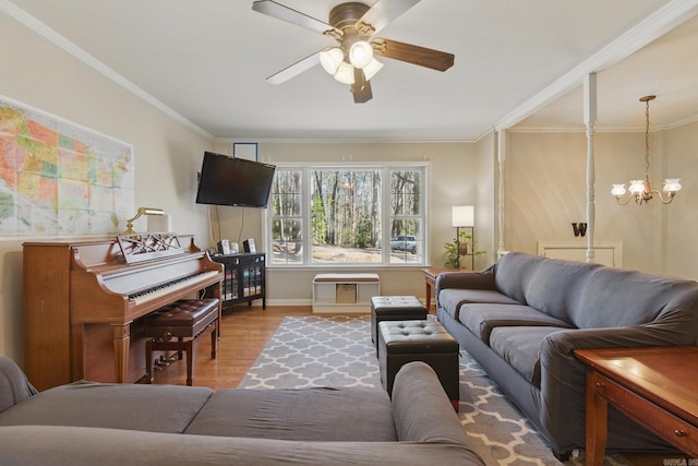 living area featuring ceiling fan with notable chandelier, baseboards, ornamental molding, and wood finished floors