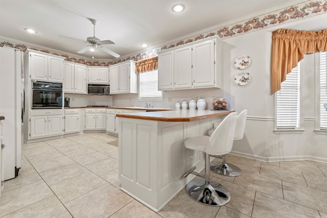 kitchen featuring black appliances, white cabinets, light tile patterned floors, and a ceiling fan