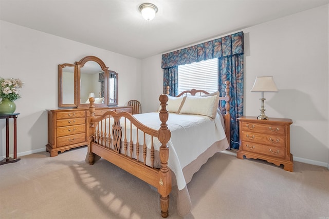 bedroom featuring light carpet and baseboards