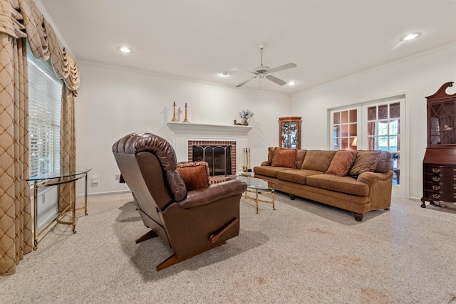 living area featuring ornamental molding, a fireplace, carpet floors, and ceiling fan