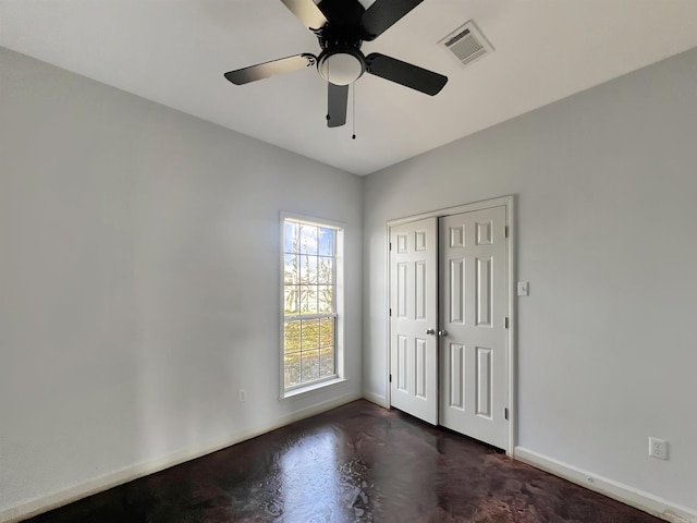 unfurnished bedroom with concrete floors, visible vents, baseboards, and a closet