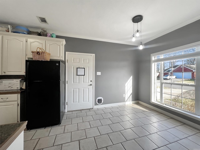 kitchen featuring dark countertops, white cabinets, crown molding, and freestanding refrigerator