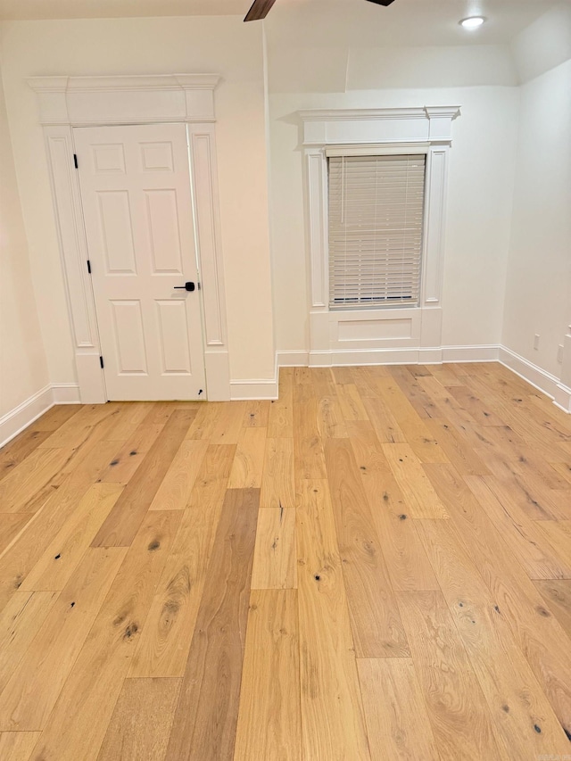 unfurnished room with a ceiling fan, baseboards, and wood-type flooring