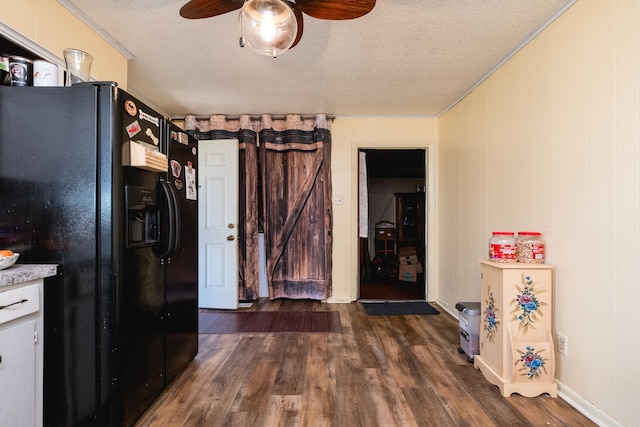 kitchen featuring black fridge, a textured ceiling, dark wood-style floors, light countertops, and ceiling fan