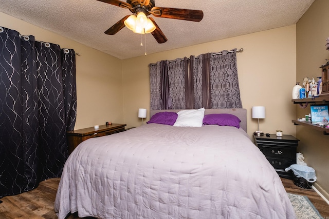 bedroom with a textured ceiling, wood finished floors, and a ceiling fan