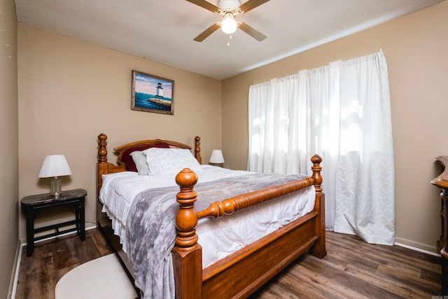 bedroom featuring ceiling fan, wood finished floors, baseboards, and a textured ceiling