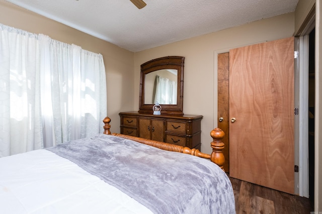 bedroom featuring a textured ceiling, a ceiling fan, and wood finished floors