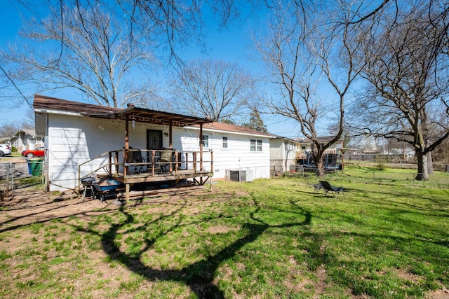 rear view of property with a yard, cooling unit, a deck, and fence