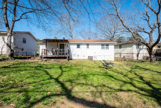 back of property featuring crawl space, a lawn, a wooden deck, and fence