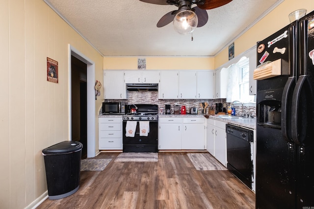 kitchen featuring dark wood-style floors, ceiling fan, black appliances, under cabinet range hood, and white cabinetry