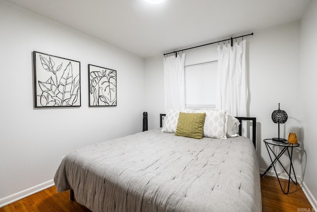 bedroom featuring baseboards and wood finished floors