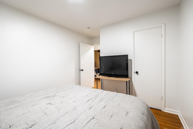 bedroom featuring wood finished floors and baseboards