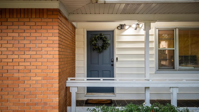 view of exterior entry with brick siding