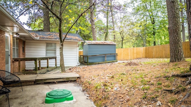 view of yard featuring an outdoor structure, a shed, and fence