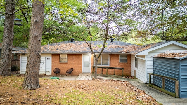 back of property featuring brick siding