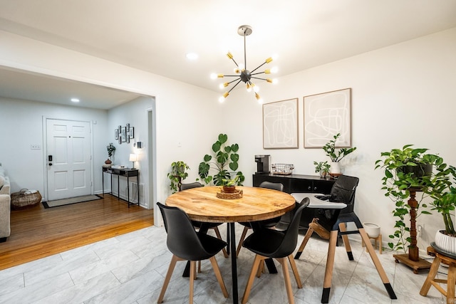 dining area featuring light wood-style floors and a notable chandelier