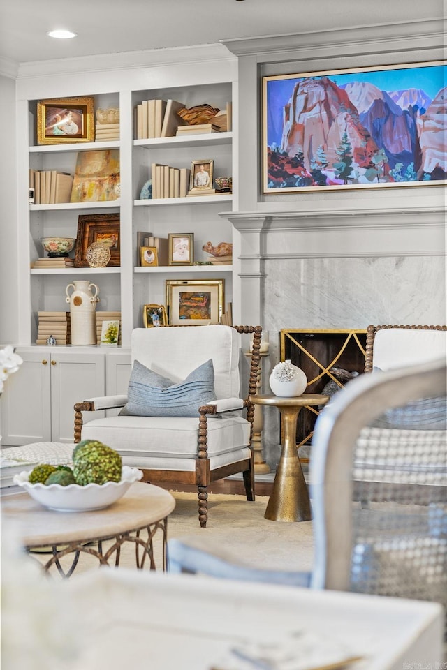 sitting room with a fireplace and ornamental molding