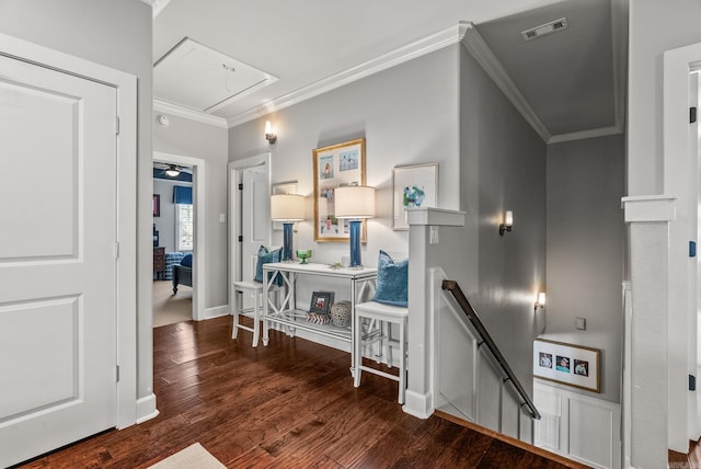 hall featuring visible vents, crown molding, attic access, an upstairs landing, and wood finished floors