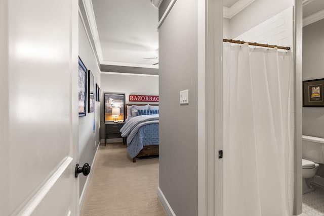 ensuite bathroom with baseboards, ensuite bath, ceiling fan, crown molding, and toilet