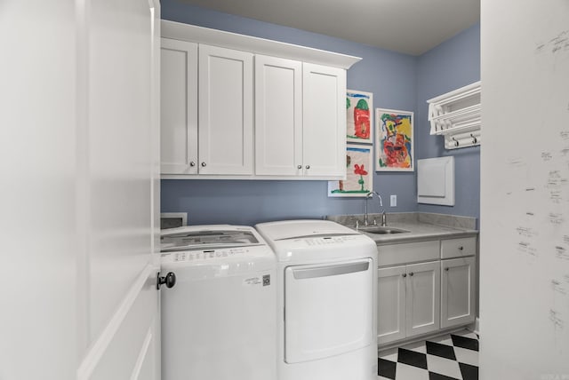 laundry area featuring washer and clothes dryer, cabinet space, tile patterned floors, and a sink