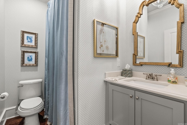 bathroom with wallpapered walls, toilet, vanity, and wood finished floors