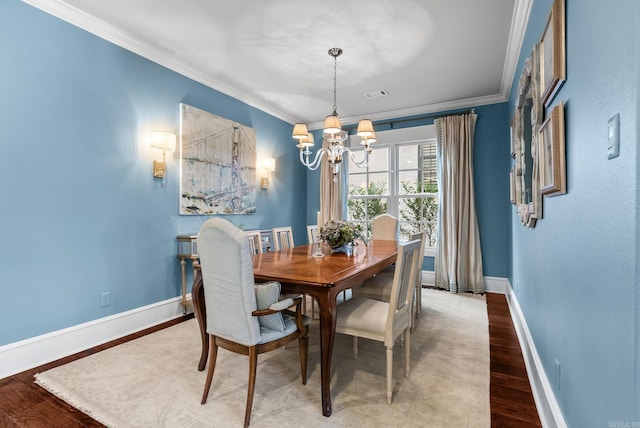 dining area featuring wood finished floors, baseboards, visible vents, an inviting chandelier, and ornamental molding