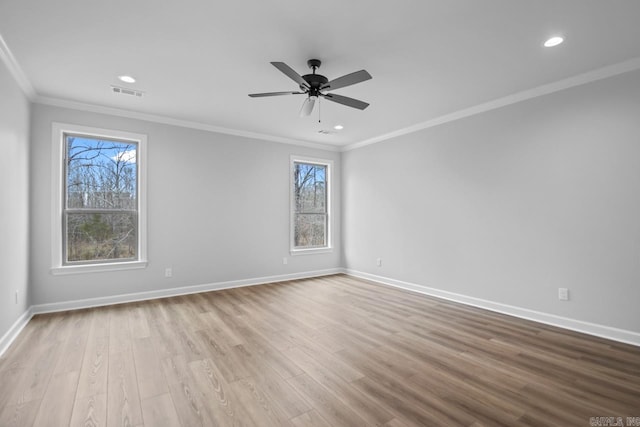 unfurnished room featuring ornamental molding, wood finished floors, visible vents, and baseboards