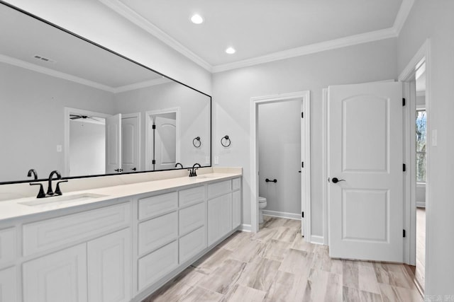 full bathroom featuring visible vents, toilet, double vanity, ornamental molding, and a sink