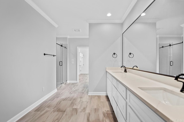 full bathroom featuring a stall shower, crown molding, and a sink