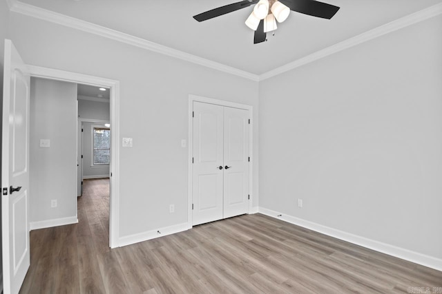 unfurnished bedroom with baseboards, wood finished floors, and ornamental molding