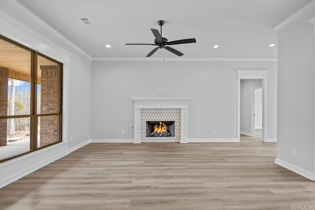 unfurnished living room with light wood-style floors, baseboards, crown molding, and ceiling fan