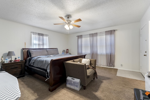 bedroom with a textured ceiling, a ceiling fan, and carpet