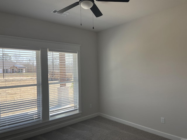 empty room with carpet flooring, baseboards, visible vents, and ceiling fan